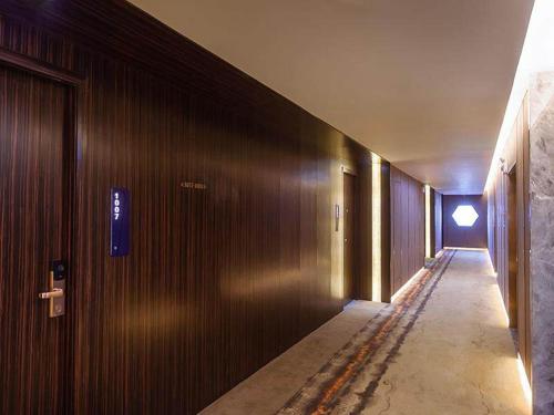 a hallway of a building with wooden walls at Kyriad Marvelous Hotel Weihai Railway Station in Weihai