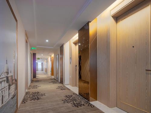 a hallway of a building with wood floors and a hallway sidx sidx sidx at Vienna International Jiangsu Wuxi Taihu Expo Center in Wuxi