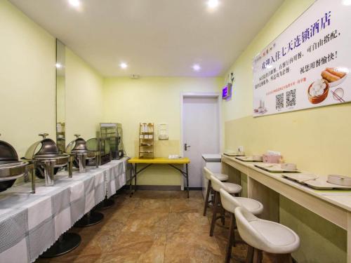a fast food restaurant with tables and stools at 7Days Inn Danyang Train Station Wuyue Square Branch in Zhenjiang
