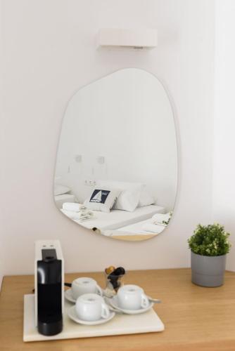 a mirror on a table with tea cups and a coffee maker at Hotel Bilia in Naousa