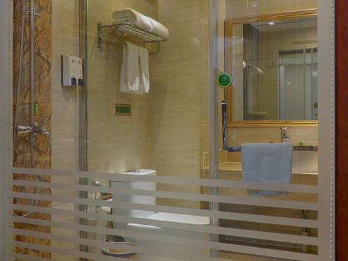 e bagno con doccia, servizi igienici e lavandino. di Vienna Hotel Jiangsu Danyang Railway Station a Danyang