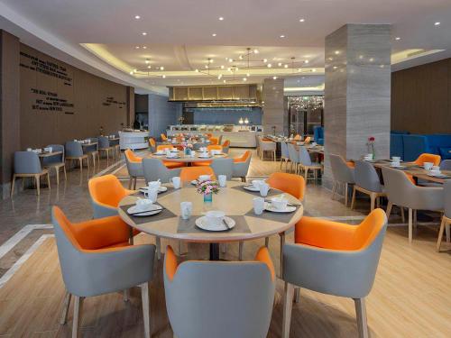 a dining room with tables and chairs in a restaurant at Kyriad Marvelous Hotel Tai'an City Hall Plaza in Tai'an