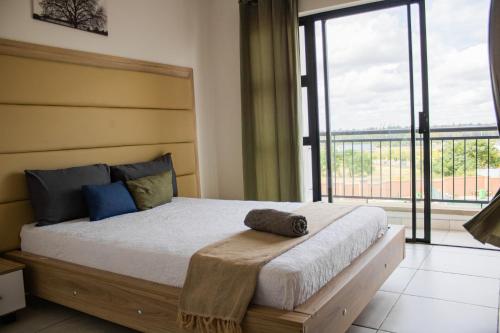 a bedroom with a large bed with a large window at 5 The Blyde Crystal Clear 2 Bedroom Apartment in Pretoria