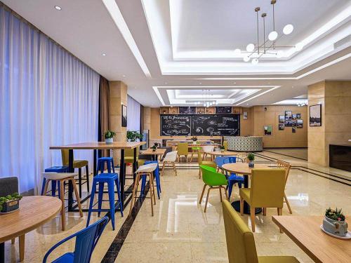 Campanile ShenZhen Longhua Dalang Business Centre في Lung Wa: مطعم فيه طاولات وكراسي في الغرفة