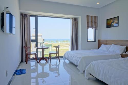 a hotel room with two beds and a view of the ocean at BeSea Hotel in Danang