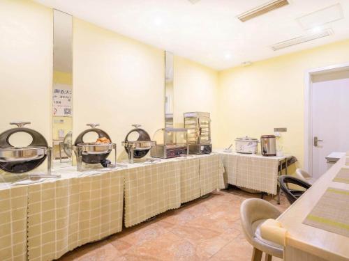 a kitchen with a row of counter tops in a restaurant at 7Days Inn Danyang Train Station Wuyue Square Branch in Zhenjiang