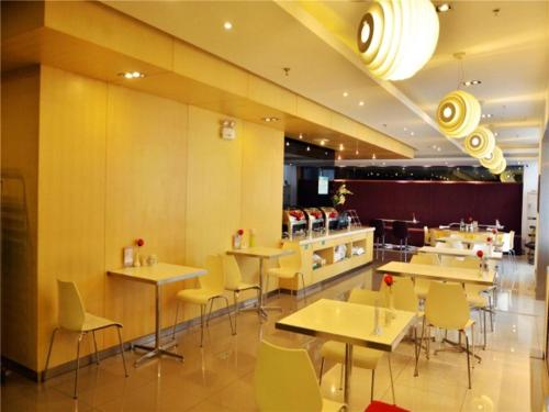 un restaurante con mesas, sillas y una barra en Jinjiang Inn Changchun Railway Station New Branch, en Changchún