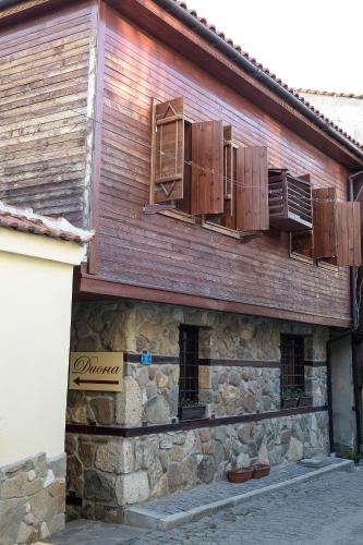 an old stone building with windows and wooden shutters at House Diona in Sozopol