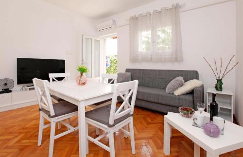 a living room with a white table and a couch at Apartman Žuvela in Vela Luka