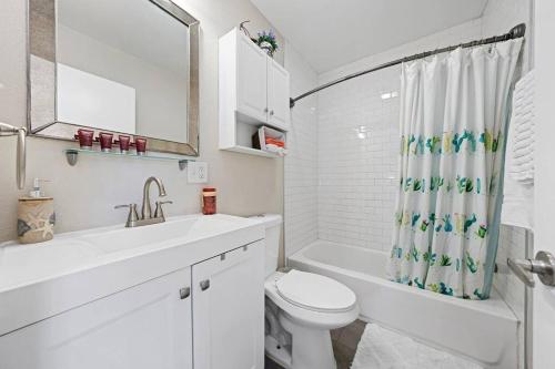 Baño blanco con aseo y lavamanos en Cozy and Bright Centrally Located NEW 2BR Property!, en Inglewood