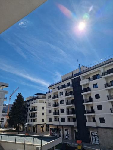 a white apartment building with the sun in the sky at The Impressive Apartment in Trebinje