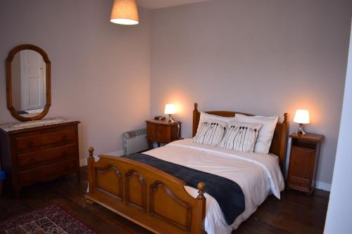 a bedroom with a bed with two lamps and a mirror at Gites in Le Neufbourg -Mortain in Le Neufbourg