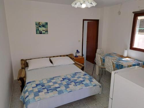 - une chambre avec un lit, une table et une fenêtre dans l'établissement Apartments Ganic, à Tribunj