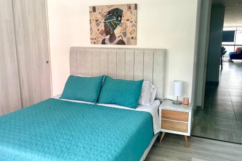1 dormitorio con 1 cama con almohadas azules en Luxury Corferias-USA Embassy & Airport Condominium, en Bogotá