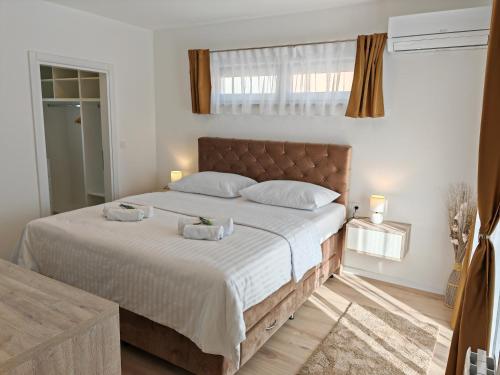 1 dormitorio con 1 cama grande y 2 toallas. en Luxury Villa Nikoma with heated pool and whirlpool, en Dicmo
