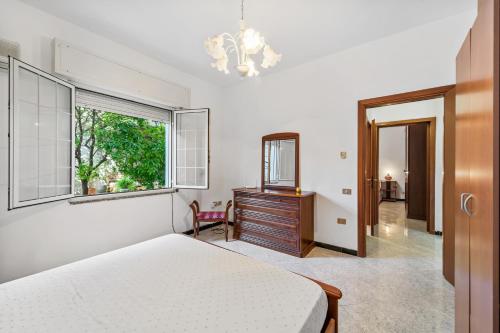 a bedroom with a bed and a dresser and a window at Garden Holiday Inn in Elmas