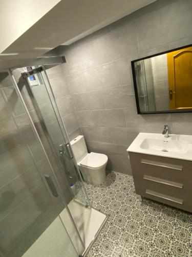 Un baño con inodoro, lavabo y espejo. en Beautiful apartment 1 minute walk to the beach, en Puerto Sagunto
