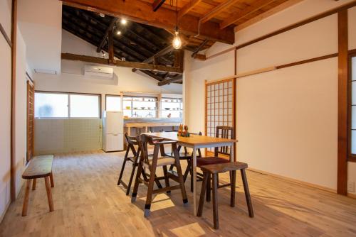 a kitchen and dining room with a table and chairs at Atelier&guesthouse ヌクリハウス in Ieyama