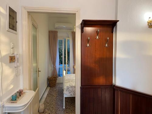 ein Badezimmer mit einer Holztür und einem Waschbecken in der Unterkunft Celena House Kitries in Avía
