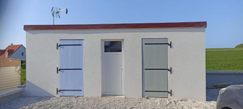 a small white building with three doors on it at Le Repos du Randonneur in Audinghen