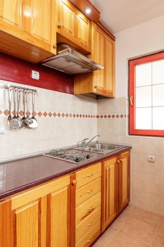 a kitchen with wooden cabinets and a sink at KRALjEVI KONACI ZLATIBOR in Zlatibor