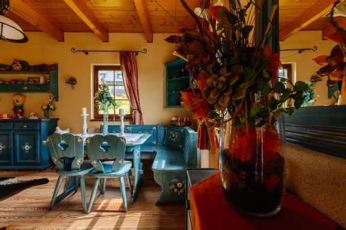 uma cozinha com armários azuis e uma mesa com um vaso de flores em Luxusní horská chata Boží Dar em Boží Dar