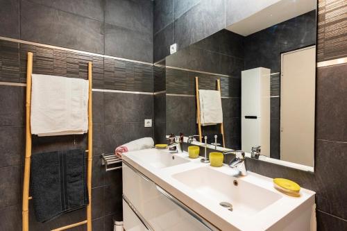 uma casa de banho com um lavatório e um espelho em Cassis, Appartement 3 chambres avec terrasse em Cassis