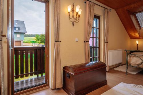 uma sala de estar com uma porta que abre para uma varanda em Luxusní horská chata Boží Dar em Boží Dar