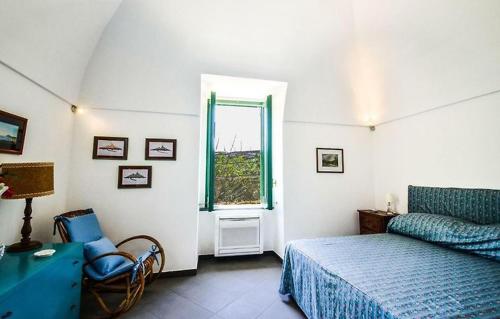 1 dormitorio con cama, ventana y silla en Casa Tiberio, en Massa Lubrense