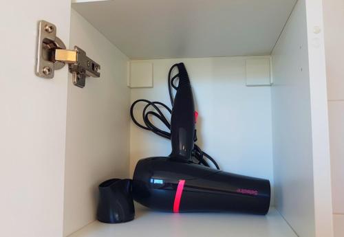 a black appliance sitting on the corner of a wall at Ferienhaus in Can Picafort, nahe Playa de Muro, 4 x Schlafzimmer mit Bad in Can Picafort
