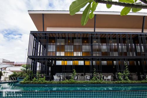 a building with a pool in front of it at Blue Lagoon Hotel in Chiang Rai