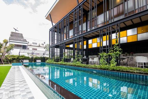 an external view of a building with a swimming pool at Blue Lagoon Hotel in Chiang Rai
