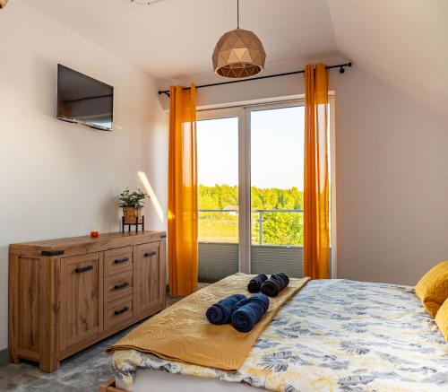 1 dormitorio con cama y ventana grande en Latarnik - luksusowe apartamenty w Stilo en Osetnik
