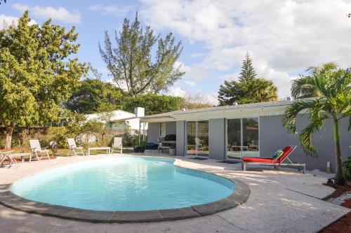 a swimming pool in front of a house at Miami Beach Villa with Sparkling Pool! Sleeps 10+! in North Miami Beach