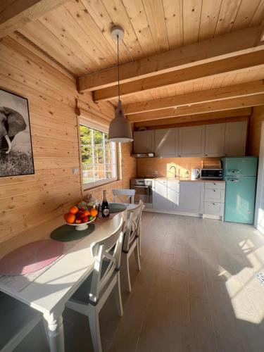 a kitchen and dining room with a table and chairs at Domki na Kaszubach u Madzi in Grabówko