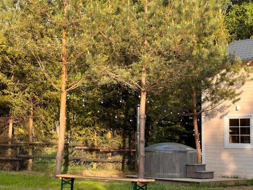 a picnic table next to a tree and a fence at Domki na Kaszubach u Madzi in Grabówko