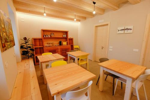 een eetkamer met houten tafels en gele stoelen bij Casa Carolina in Levico Terme
