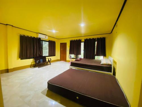 a bedroom with two beds in a room with yellow walls at Banana Resort in Ko Phayam