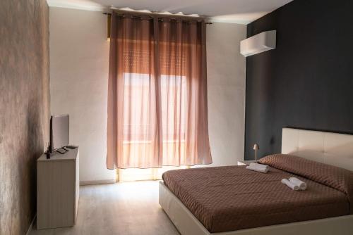 a bedroom with a bed and a large window at Monfalcone City Room Rental Apartment in Cagliari