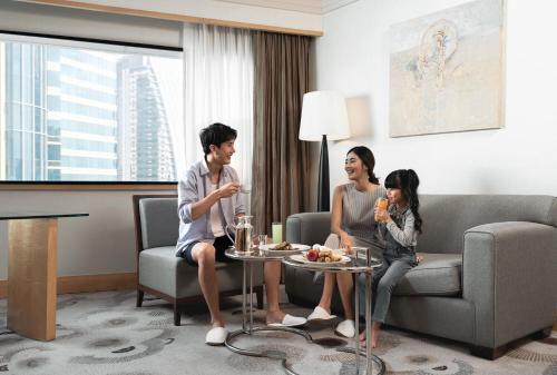 a family sitting in a living room in a hotel room at The Westin Grande Sukhumvit, Bangkok in Bangkok