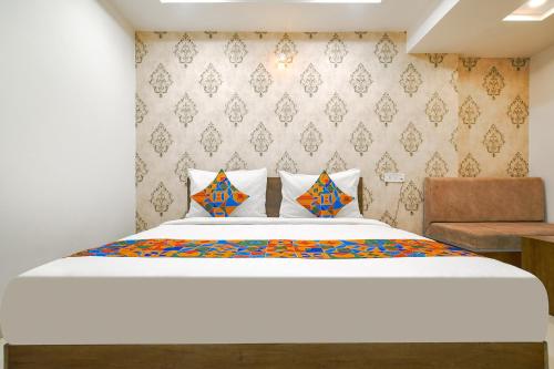 a bedroom with a large bed and a chair at FabHotel Ten Eleven in Indore