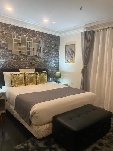 a bedroom with a large bed and a brick wall at MAKATI Isabela Luxury in Manila