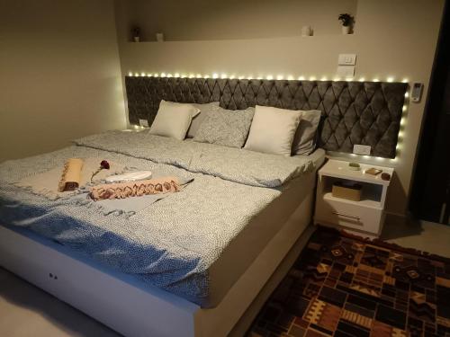 a bedroom with a bed with a blue comforter at WestLuxApartment in Al Karnak