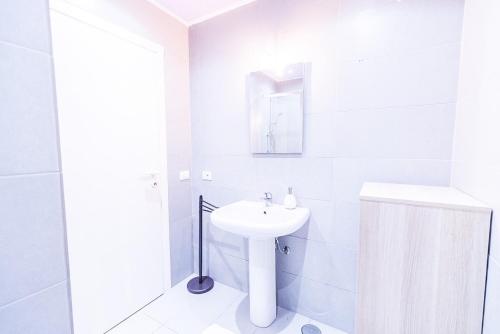 uma casa de banho branca com um lavatório e um espelho em Liguria Garden em Olbia