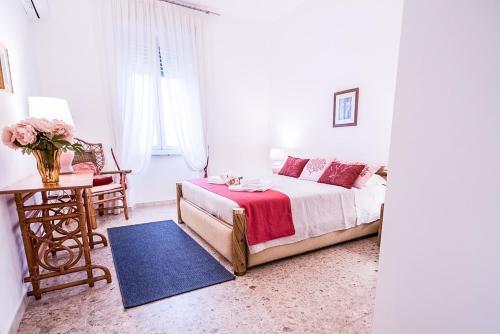 um quarto com uma cama e uma mesa com um vaso de flores em Liguria Garden em Olbia