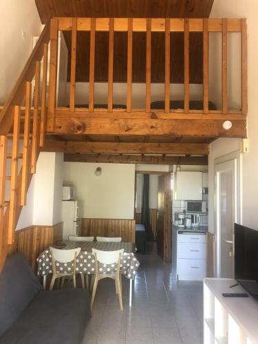 - un salon avec un escalier, une table et des chaises dans l'établissement Residence la Catalane, à Saint Cyprien Plage