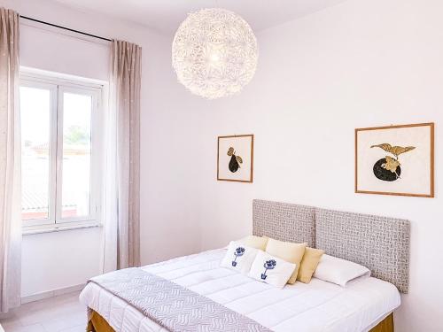 a white bedroom with a bed and a window at Liguria Terrace in Olbia