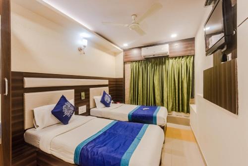 a hotel room with two beds and a window at OYO Hotel Royal Grand Near Chhatrapati Shivaji International Airport in Mumbai