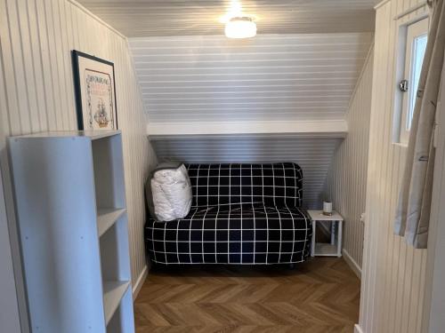 Cette petite chambre comprend un canapé. dans l'établissement Studio cabine avec parking près de la plage - FR-1-487-353, à Varaville