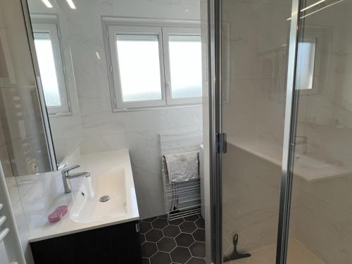 une salle de bain blanche avec une douche et un lavabo dans l'établissement Studio cabine avec parking près de la plage - FR-1-487-353, à Varaville